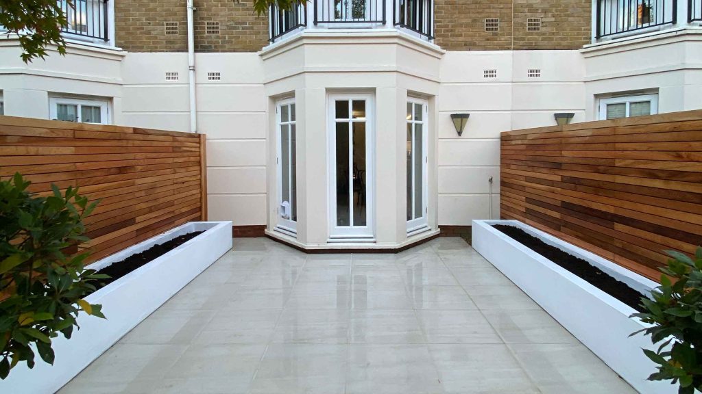 Courtyard garden in Richmond with white rendered planters and cedar fencing.
