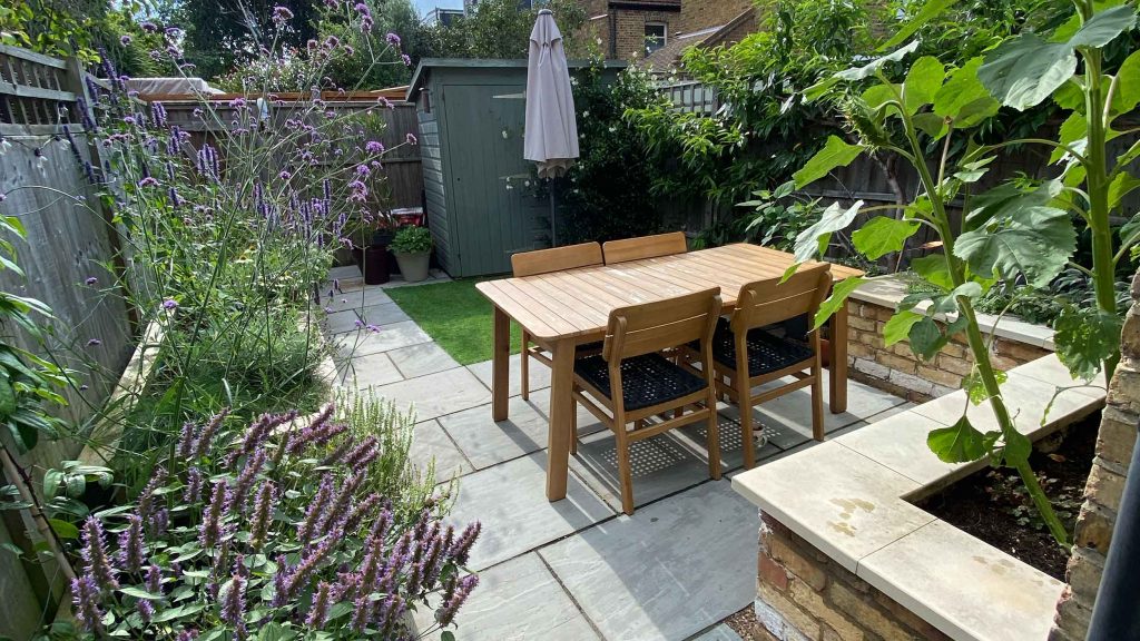 A small garden in Twickenham which we designed and built using sandstone for the patio and softwood sleepers for raised beds.