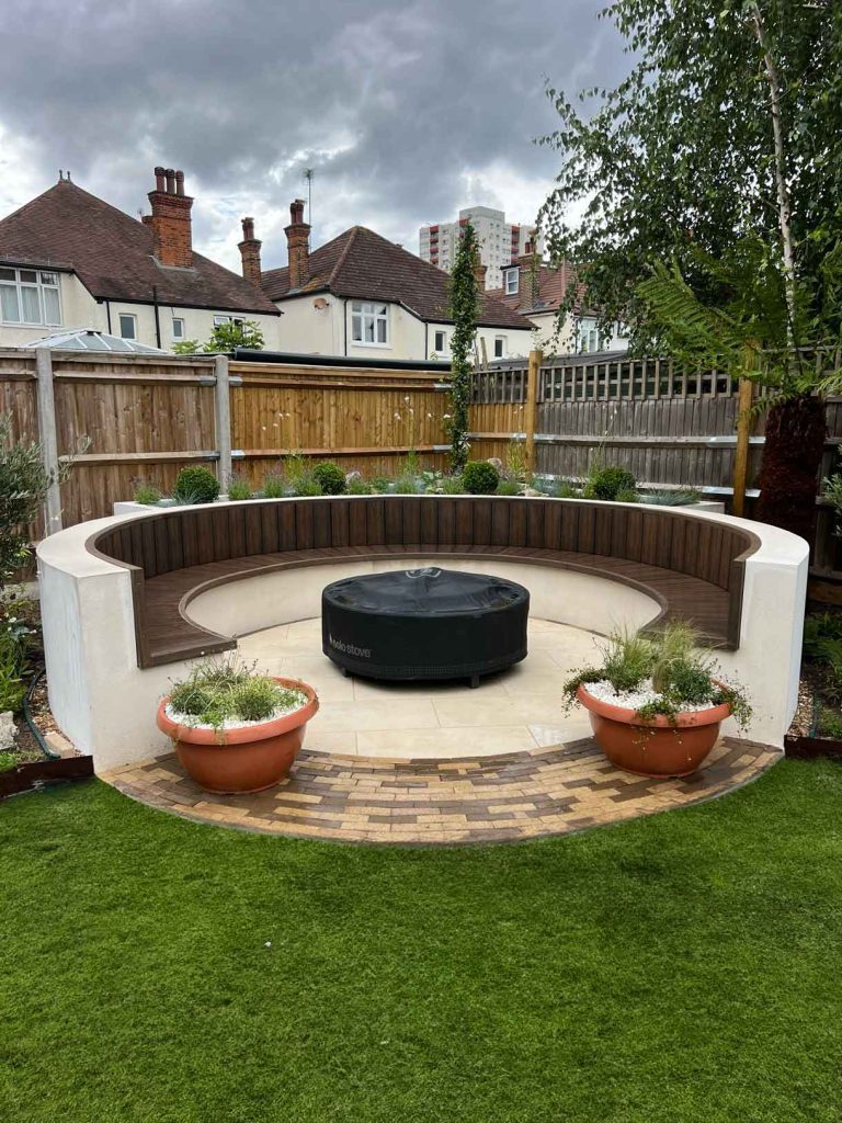 A rendered circular seating area also made from composite with a fire pit in the middle.