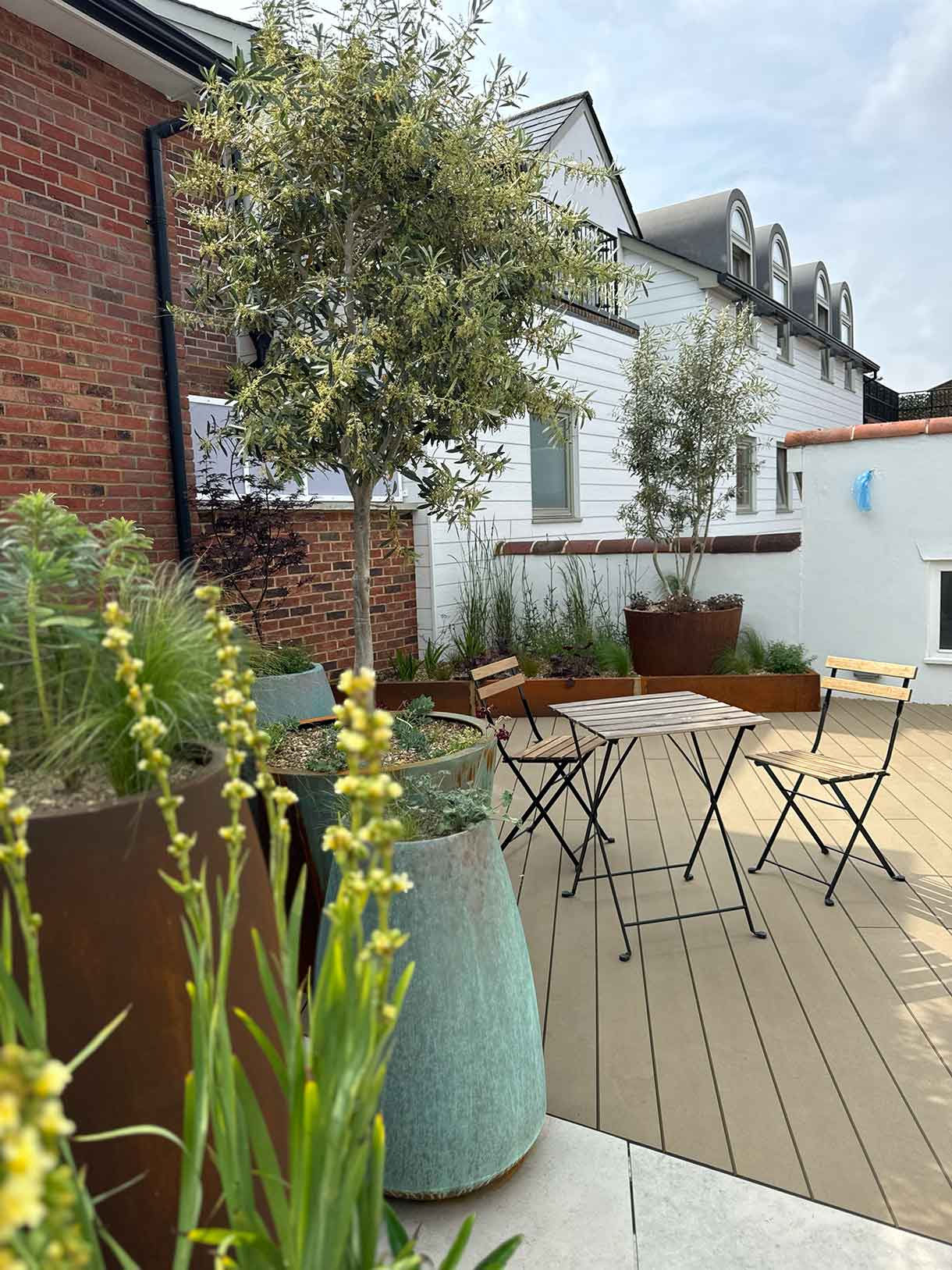 Close-up of planting in large decorative planters on roof terrac