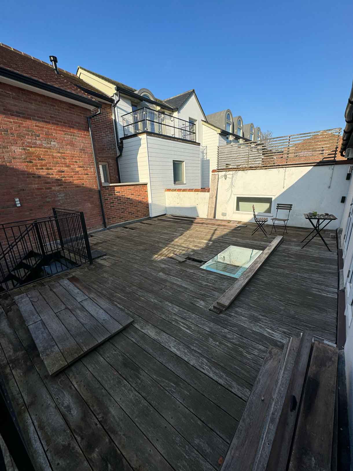 Roof terrace with old decking stripped back, exposing the roof surface.