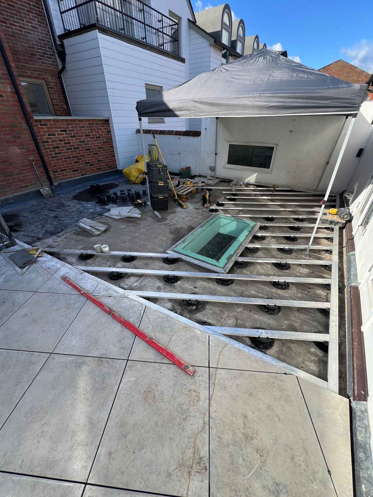 9. Roof terrace mid-construction with decking removed and skylight visible.