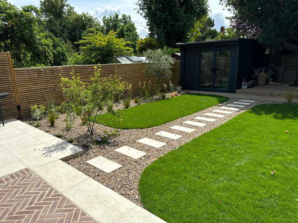 Garden view with stepping stone path across lawn toward rear studio.