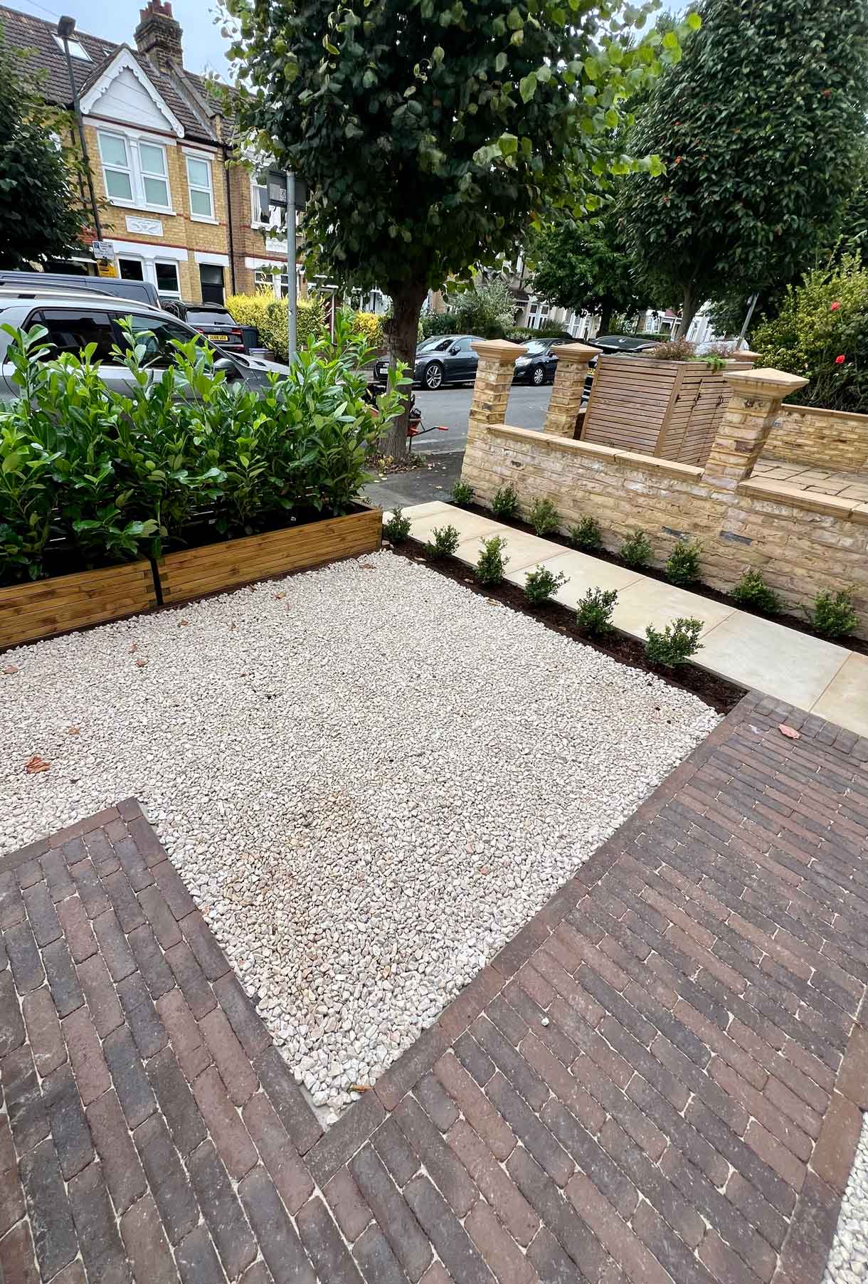 Flowering border with lush planting along a slatted timber fence.