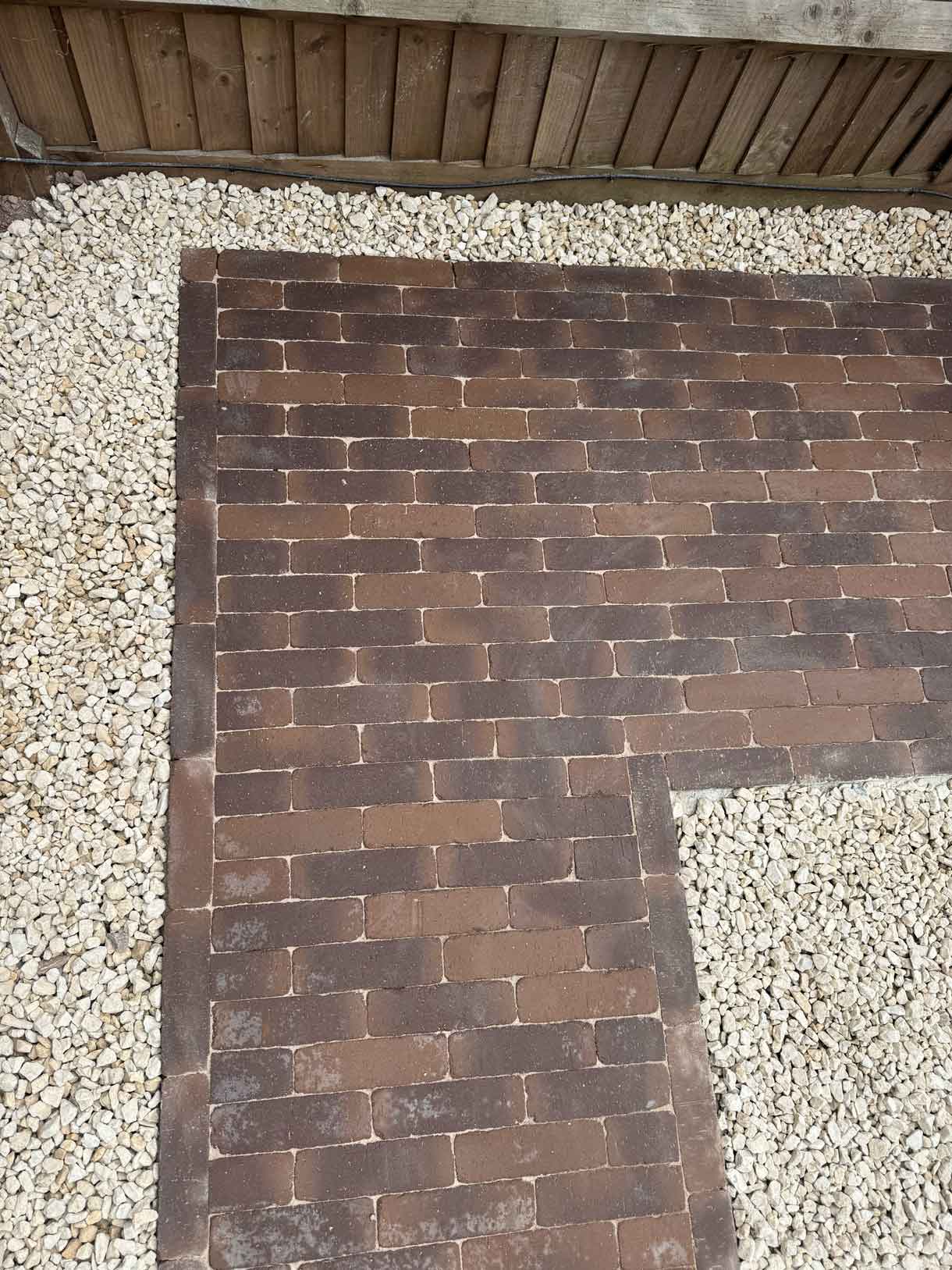 Gravel area framed by brick pavers at the front of the property.