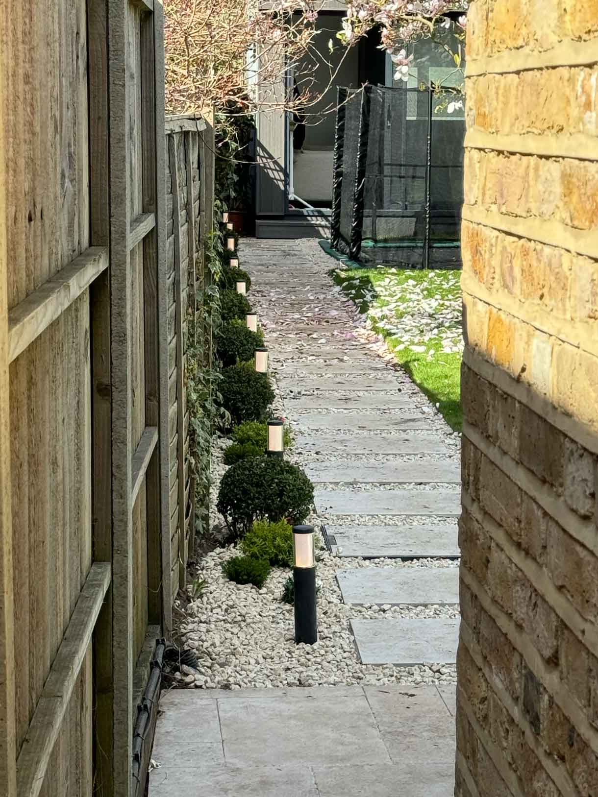 Stepping-stone path along a side garden with gravel mulch and evergreen planting.