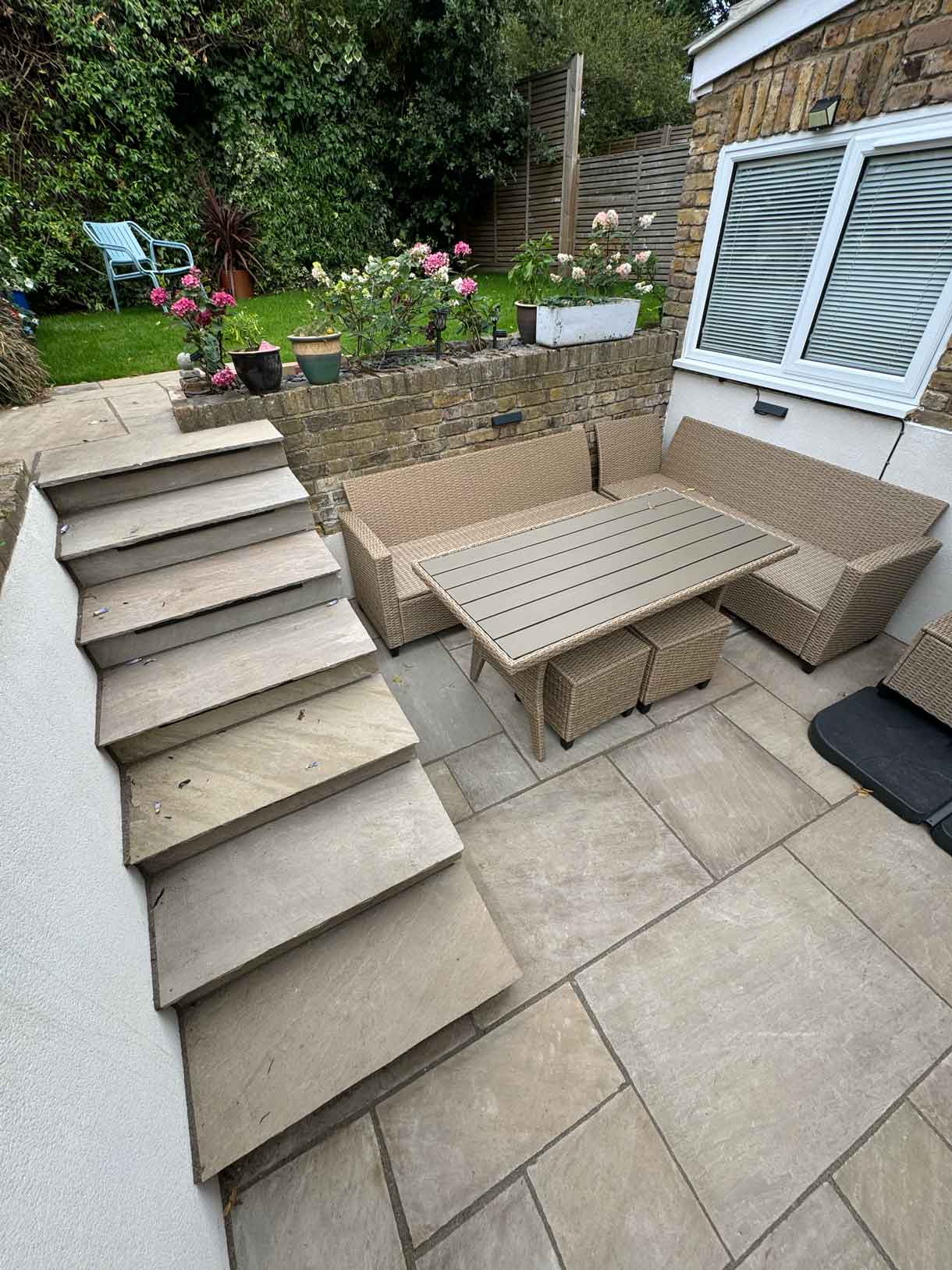 Garden shown before works, with patchy lawn and uneven edges.