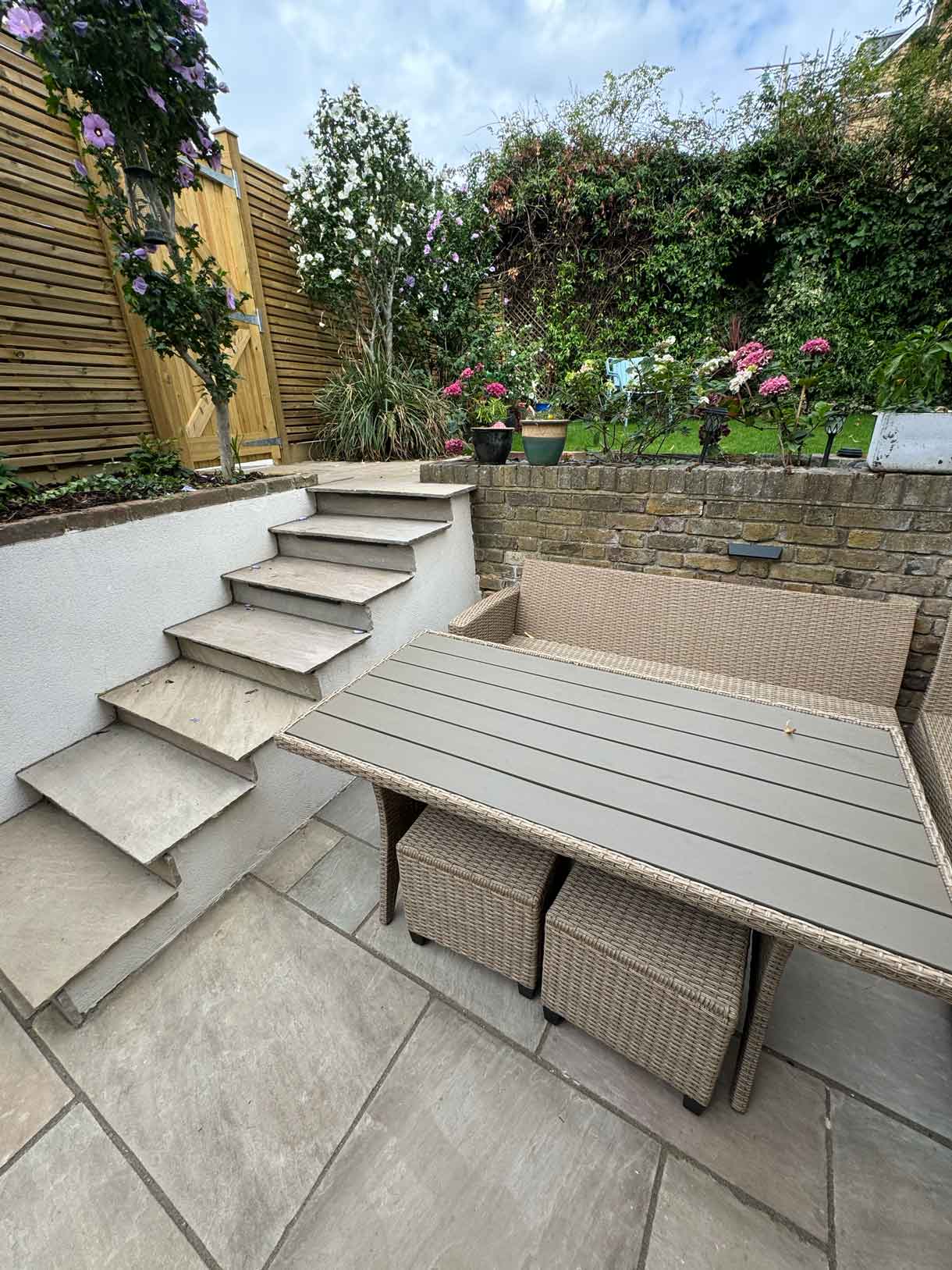 Corner seating area with built-in bench and wide steps leading from the lower patio to the upper level.